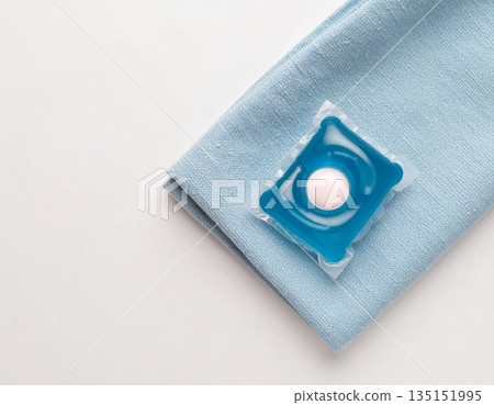 Home cleaning. Soluble laundry detergent capsule on a neutral linen cloth with empty space for text. Home cleaning. Soluble laundry detergent capsule on a neutral linen cloth with empty space for text. 135151995