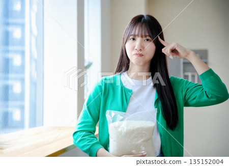 Young woman holding rice 135152004