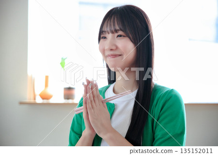 A young woman eating rice A young woman eating rice 135152011