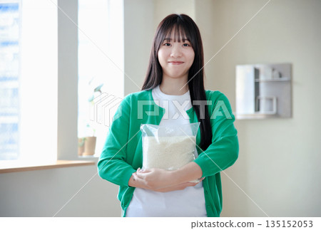 年輕女子手捧米 135152053