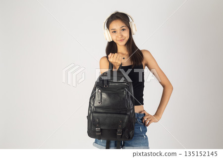 Teenager girl with a backpack looking over her shoulder. Teenager girl with a backpack looking over her shoulder. 135152145