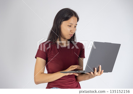 Woman sitting on a sofa and using a laptop. Woman sitting on a sofa and using a laptop. 135152156