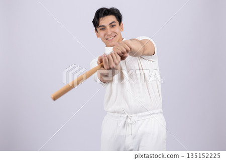 Man holding a wooden stick in a baseball pose. 135152225