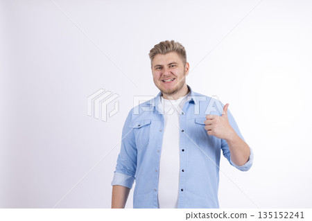Happy man in a light blue shirt showing a thumbs up. Happy man in a light blue shirt showing a thumbs up. 135152241
