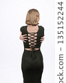 Back view of a woman in a black dress with lacing. 135152244