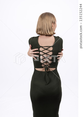 Back view of a woman in a black dress with lacing. Back view of a woman in a black dress with lacing. 135152244