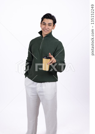 Man in a green sweatshirt holding a paper cup and looking. Man in a green sweatshirt holding a paper cup and looking. 135152249