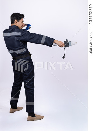 Professional worker in uniform checking a measuring tape. 135152250