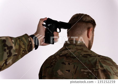 Soldier pointing a handgun at a prisoner's head. Soldier pointing a handgun at a prisoner's head. 135152259