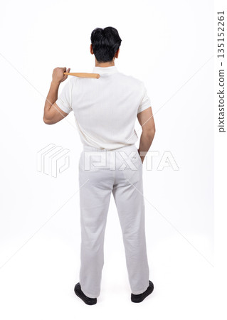 Man standing with his back to the camera holding a stick. 135152261