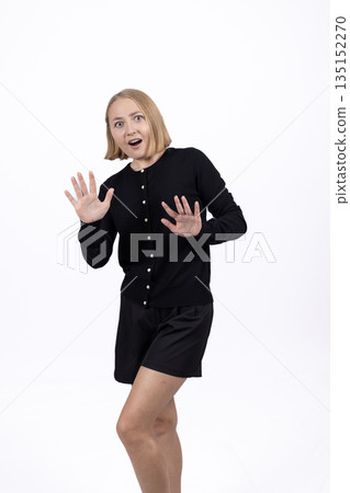 Scared or surprised woman recoiling in a black dress. Scared or surprised woman recoiling in a black dress. 135152270