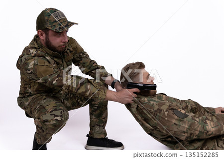 Soldier in camouflage uniform performing a tactical arrest. Soldier in camouflage uniform performing a tactical arrest. 135152285