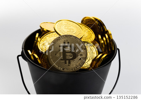 Close-up of a black bucket full of golden bitcoin coins. Close-up of a black bucket full of golden bitcoin coins. 135152286