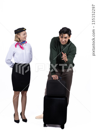 Flight attendant standing with a passenger and suitcase. Flight attendant standing with a passenger and suitcase. 135152297