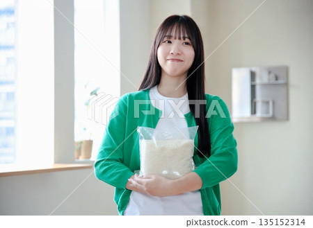 Young woman holding rice 135152314