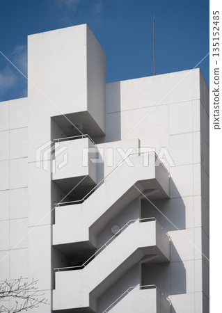 White fire escape stairs climbing a modern building White fire escape stairs climbing a modern building 135152485