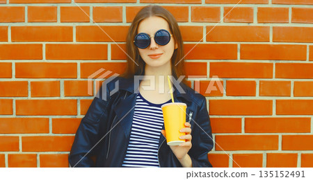Stylish happy modern young woman with cup of juice in black jacket, glasses, smiling teenage girl 135152491