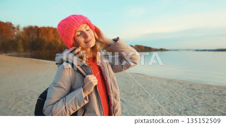Travel, adventure, traveler woman on beach at sunset, enjoying landscape, on sea coast background 135152509