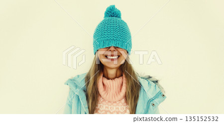 Portrait of happy funny smiling young woman in blue winter hat having fun on white background Portrait of happy funny smiling young woman in blue winter hat having fun on white background 135152532