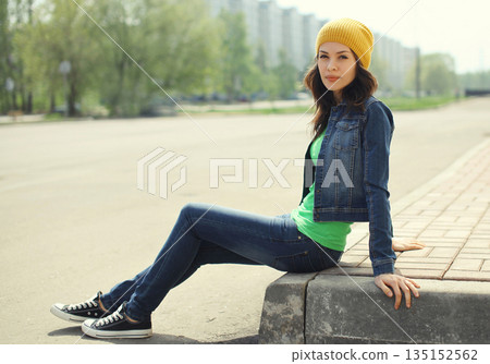 Beautiful brunette young woman in casual on city street Beautiful brunette young woman in casual on city street 135152562