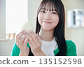 A young woman eating rice balls with relish A young woman eating rice balls with relish 135152598