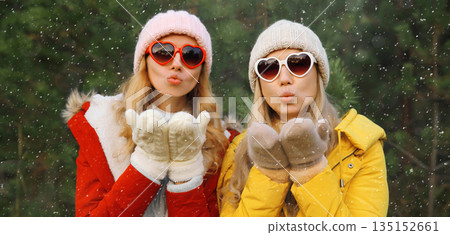 Happy women friends having fun, celebration, girlfriends on Christmas tree in winter with snow 135152661