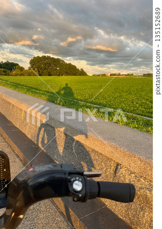 A person is riding a scooter on a road with a wall on the side A person is riding a scooter on a road with a wall on the side 135152689