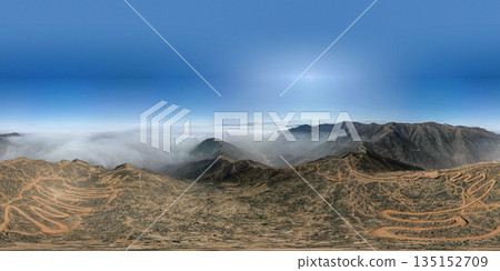 A panoramic shot of a mountain range with a cloudy sky in the background A panoramic shot of a mountain range with a cloudy sky in the background 135152709
