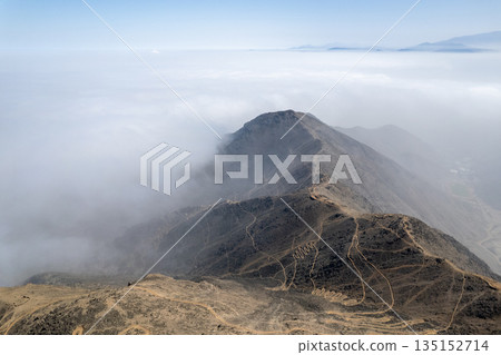 The sky is cloudy and the mountain is covered in fog The sky is cloudy and the mountain is covered in fog 135152714