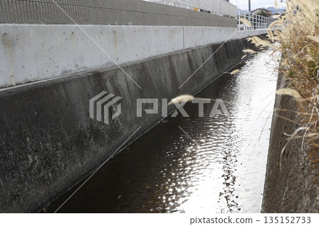 A view of water flowing through a concrete irrigation channel. A view of water flowing through a concrete irrigation channel. 135152733