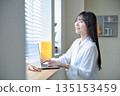 A woman in her twenties operating a laptop A woman in her twenties operating a laptop 135153459