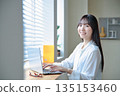 A woman in her twenties operating a laptop A woman in her twenties operating a laptop 135153460