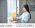 A woman in her twenties operating a laptop A woman in her twenties operating a laptop 135153461