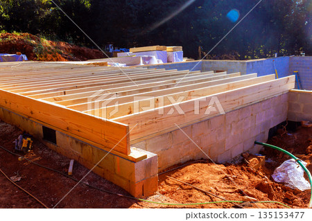 Workers are constructing new building with wooden beams on cinder block foundation Workers are constructing new building with wooden beams on cinder block foundation 135153477