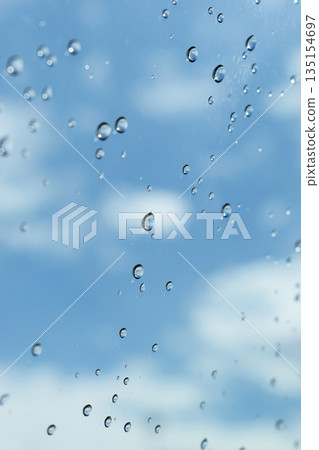 water drop on mirror with blue sky and white cloud background 135154697
