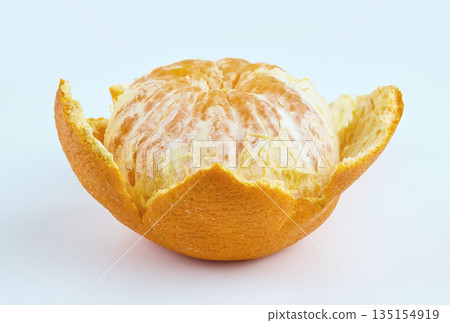 A fresh whole mandarin orange partially peeled, showing juicy segments against a clean white backdrop 135154919