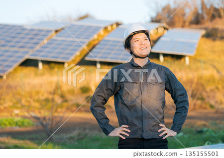 A worker standing in front of a solar panel 135155501