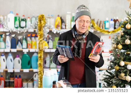 Senior man select and studies label razor on New Year Eve 135155523