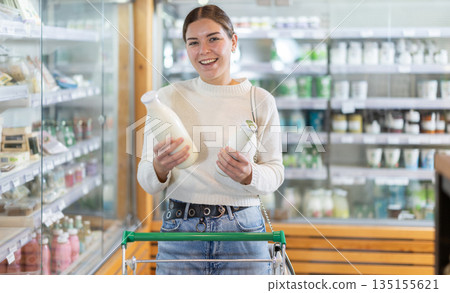 Young woman choosing milk in grocery supermarket 135155621