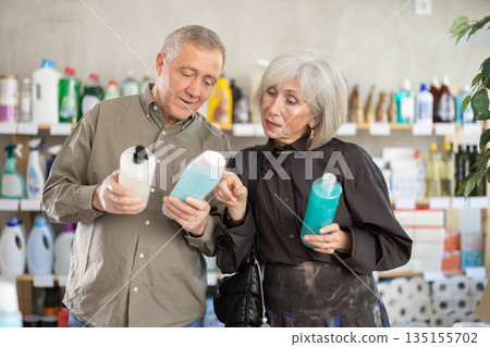 Couple man and woman choosing shampoo or shower gel in store Couple man and woman choosing shampoo or shower gel in store 135155702
