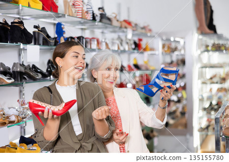 Elderly woman and young woman choosing stilettos in shoe store Elderly woman and young woman choosing stilettos in shoe store 135155780