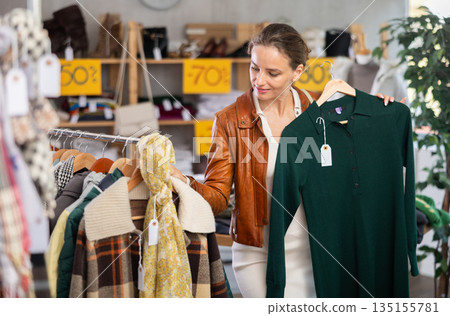 During November sales, woman choose and buy warm knitted dress 135155781