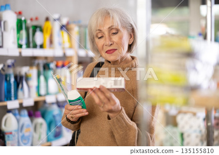 Mature woman choosing tooth care products in department store Mature woman choosing tooth care products in department store 135155810