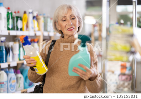 Mature woman choosing cleaning spray in department store 135155831