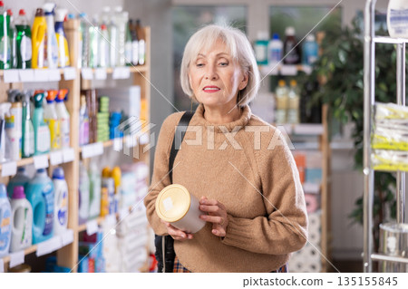 woman chooses laundry detergent 135155845