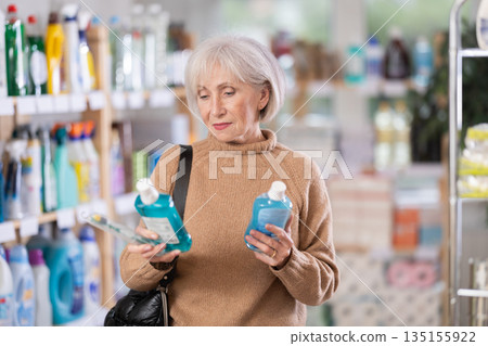 Mature woman choosing tooth care products in department store Mature woman choosing tooth care products in department store 135155922