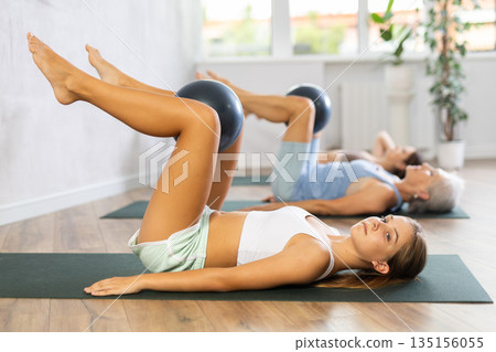 Teenage girl doing pilates with soft ball in group 135156055
