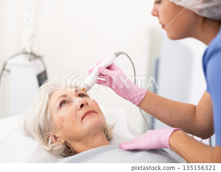 Old woman having face radiolifting procedure Old woman having face radiolifting procedure 135156321