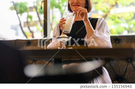 一位二十多歲的日本女性在咖啡館享用冷飲 一位二十多歲的日本女性在咖啡館享用冷飲 135156948