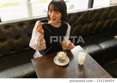 年輕女子在咖啡館享用甜點 年輕女子在咖啡館享用甜點 135156954